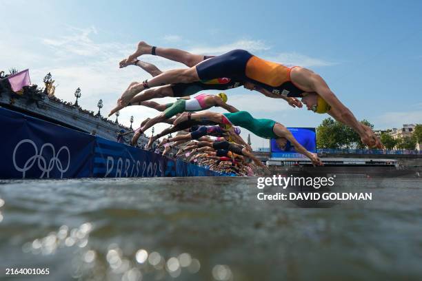 Athletes dive into the Seine river to start the swimming stage of the men's individual triathlon at the Paris 2024 Olympic Games in central Paris on...