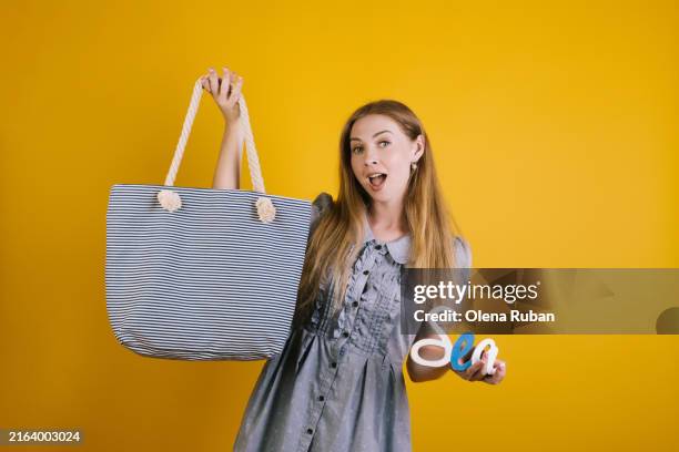 young woman holding a bag and a word sea. - boat straps stock pictures, royalty-free photos & images