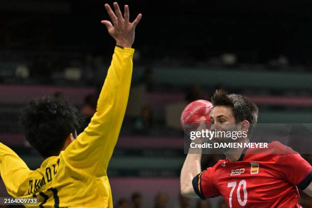Spain's left wing Daniel Fernandez attempts to score against Japan's goalkeeper Daisuke Okamoto during the Men's Preliminary Round Group A handball...