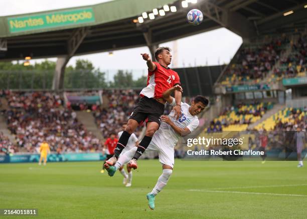 Ahmed Eid of Team Egypt and Zafarmurod Abdirakhmatov of Team Uzbekistan compete for the ball during the Men's group C match between Uzbekistan and...