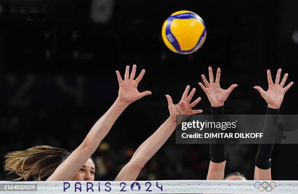Serbia's Maja Aleksic and Serbia's Katarina Lazovic block the ball during the women's preliminary round volleyball match between USA and Serbia...