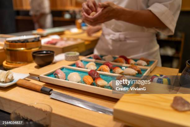 chef is making japanese omakase in the restaurant - bar à sushis photos et images de collection