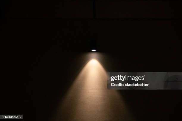 spotlight spots on a black wall - fascio di luce foto e immagini stock