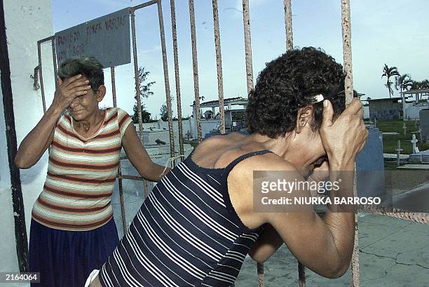 Maria Acosta Valdes and Caridad Acosta Placeres, the mothers of Luis Alberto Suarez and Yosvani Martinez respectively, cry in front of the locked...