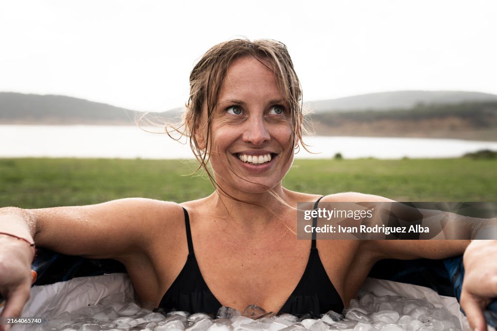 Mujer sonriente dentro de un tubo con agua helada