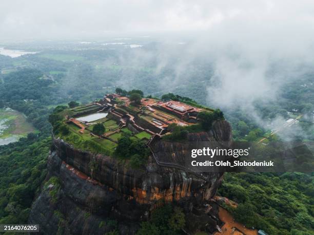 aerial view of sigiria rock in sri lanka during monsoon season covered with clouds - sri lanka stock pictures, royalty-free photos & images
