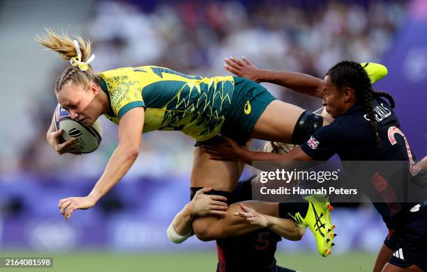 Maddison Levi of Team Australia is tackled by Heather Cowell and Jade Shekells of Team Great Britain during the Women’s Pool B match between Team...