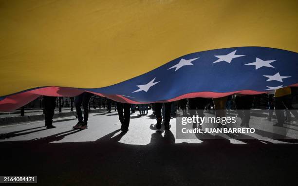 Supporters of Venezuelan President Nicolas Maduro display a Venezuelan flag during a rally in Caracas on July 31, 2024. Venezuelan President Nicolas...
