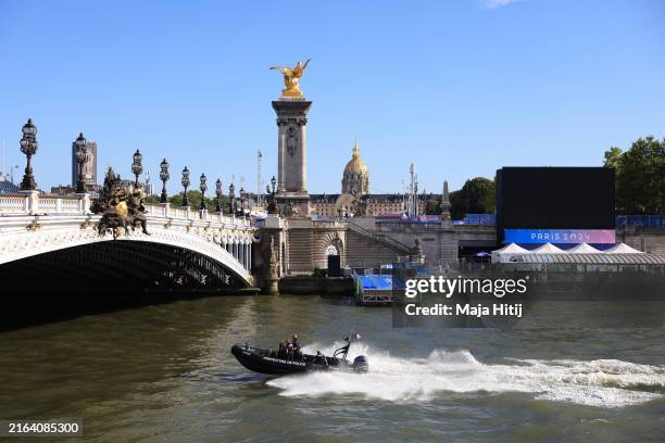 View across the Seine River as members of the Police travel on a boat, with the Pont Alexandre III, on day two of the Olympic Games Paris 2024 on...