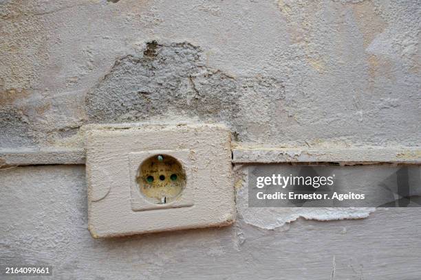 paint-covered socket on a rough, peeling wall - electrical outlet stock pictures, royalty-free photos & images