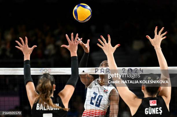 Turkey's Hande Baladin and Turkey's Zehra Gunes jump to block the ball from from Dominican Republic's Brayelin Elizabeth Martinez during the women's...
