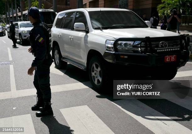 Officers of the Bolivarian National Police escort cars transporting members of the Argentina's diplomat body in Venezuela as they leave Argentina's...