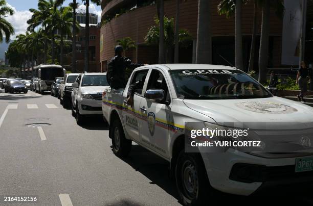 Officers of the Bolivarian National Police escort cars transporting members of the Argentina's diplomat body in Venezuela as they leave Argentina's...