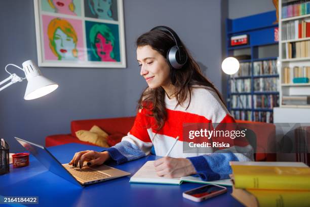 young woman studying with laptop at home - bont stockfoto's en -beelden