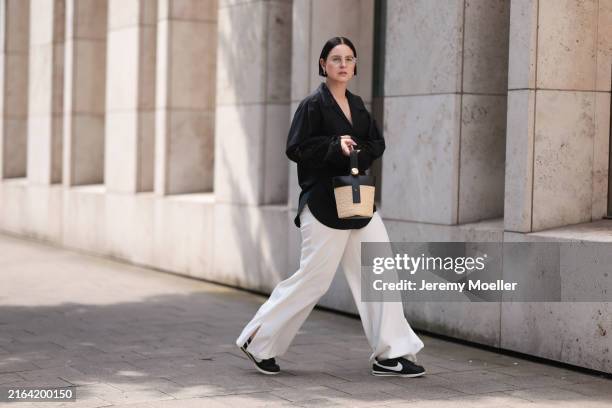 Maria Barteczko seen wearing Ray-Ban gold round retro glasses, COS gold hoop earrings, ARKET black oversized embroidered shirt, COS white wide leg...