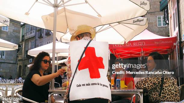 women sitting in a sidewalk cafe, buying participations for red cross lottery. - international red cross and red crescent movement stock pictures, royalty-free photos & images