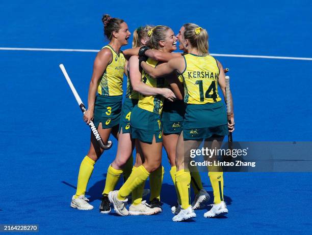 Alice Arnott of Team Australia celebrates scoring her team's second goal with teammates during the Women's Pool B match between Great Britain and...