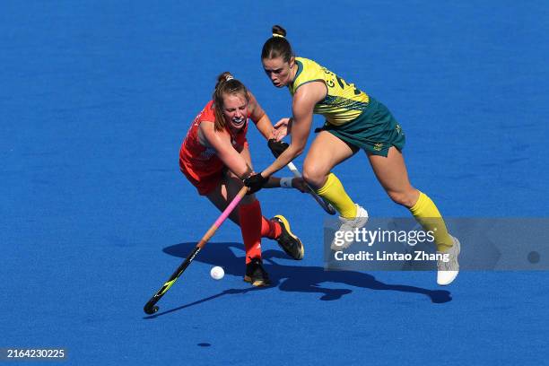 Giselle Ansley of Team Great Britain passes the ball whilst under pressure from Grace Stewart of Team Australia during the Women's Pool B match...