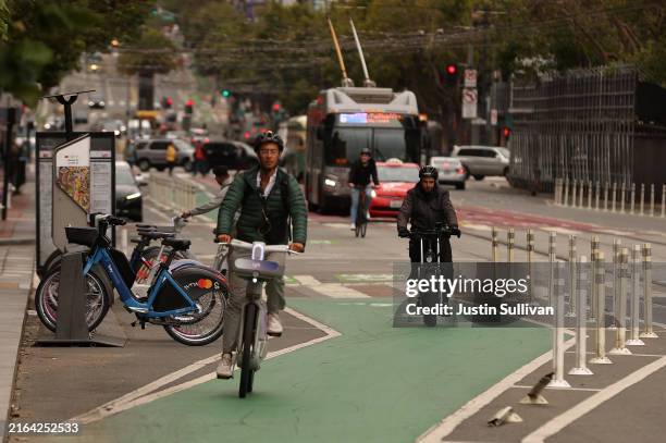 Cyclists ride e-bikes along Market Street on July 29, 2024 in San Francisco, California. According to a University of California San Francisco study,...