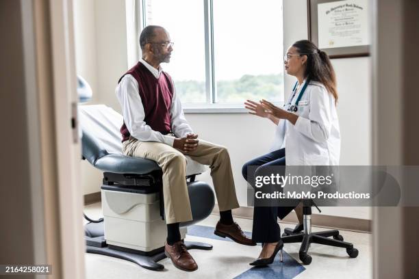 female doctor talking with senior man in exam room - doctor stethoscope patient whole body stock pictures, royalty-free photos & images