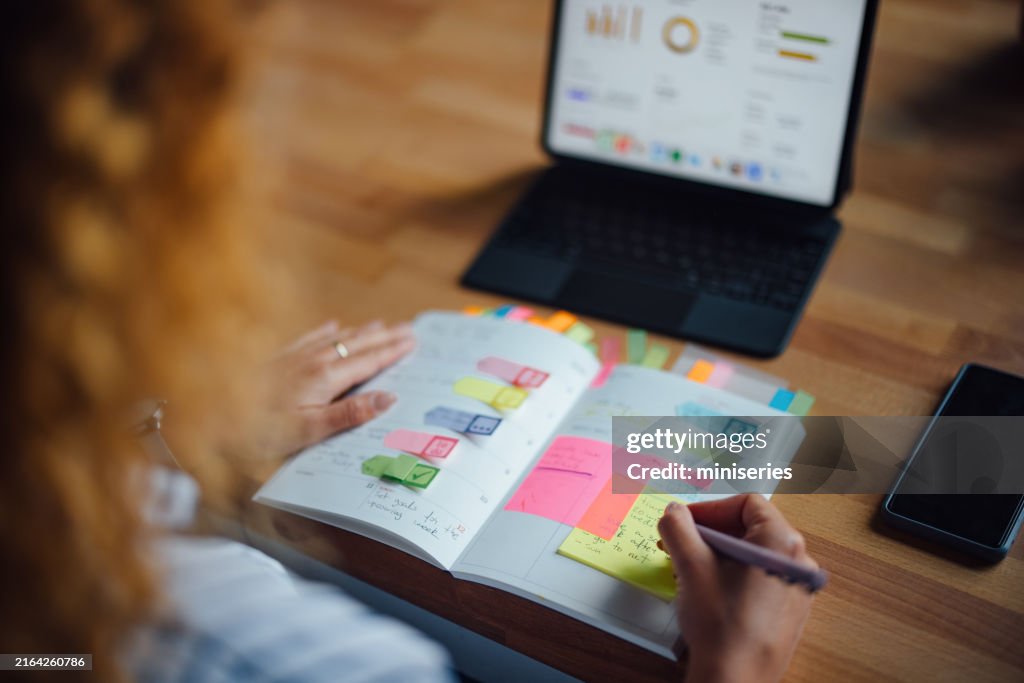 Person Planning And Writing Notes In Cozy Cafe Setting