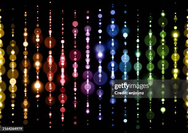 bright abstract rainbow lights background - string lights black background stock illustrations