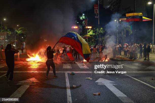 Demonstrator waves a Venezuelan flag during a protest against the official results of the presidential election on July 29, 2024 in Caracas,...