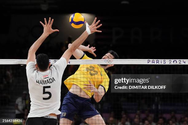 Egypt's Mohamed Osman Elhaddad jumps to block the ball from Brazil's Flavio Resende Gualberto during the men's preliminary round volleyball match...