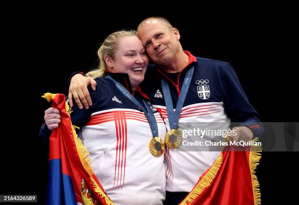 Gold medalists Zorana Arunovic and Damir Mikec of Team Serbia celebrate on the podium during the Shooting 10m Air Pistol Mixed Team medal ceremony on...