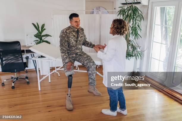 soldier with a prosthetic leg receiving medical advice. - military medical exam stock pictures, royalty-free photos & images
