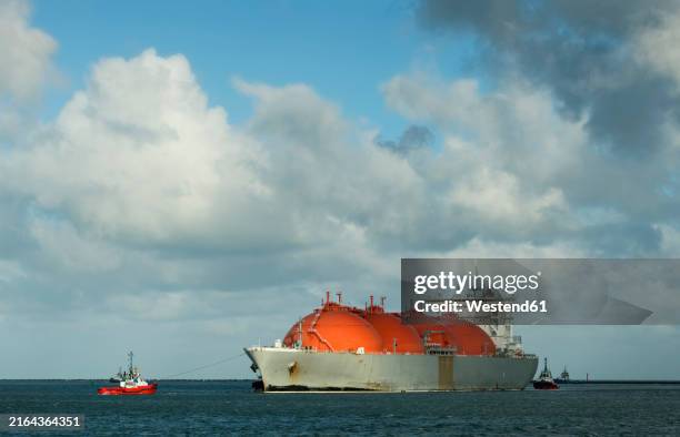 lng tanker ship arriving at rotterdam harbor under cloudy sky in netherlands - tanker stockfoto's en -beelden
