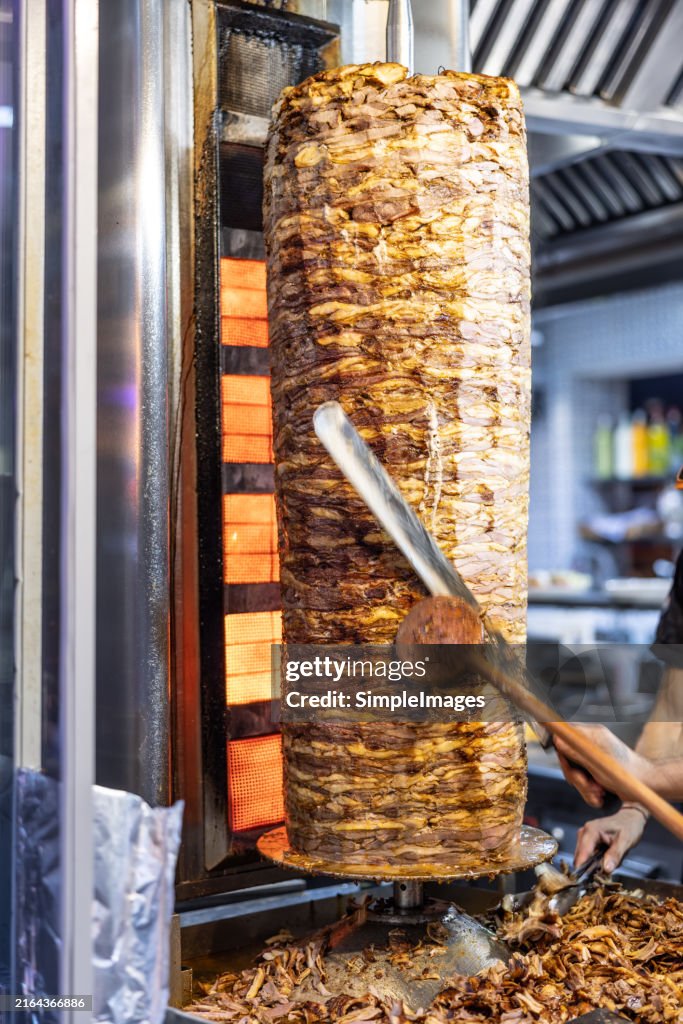 Kebab meat cooked on large skewers at a takeaway sandwich shop in Turkish Streets