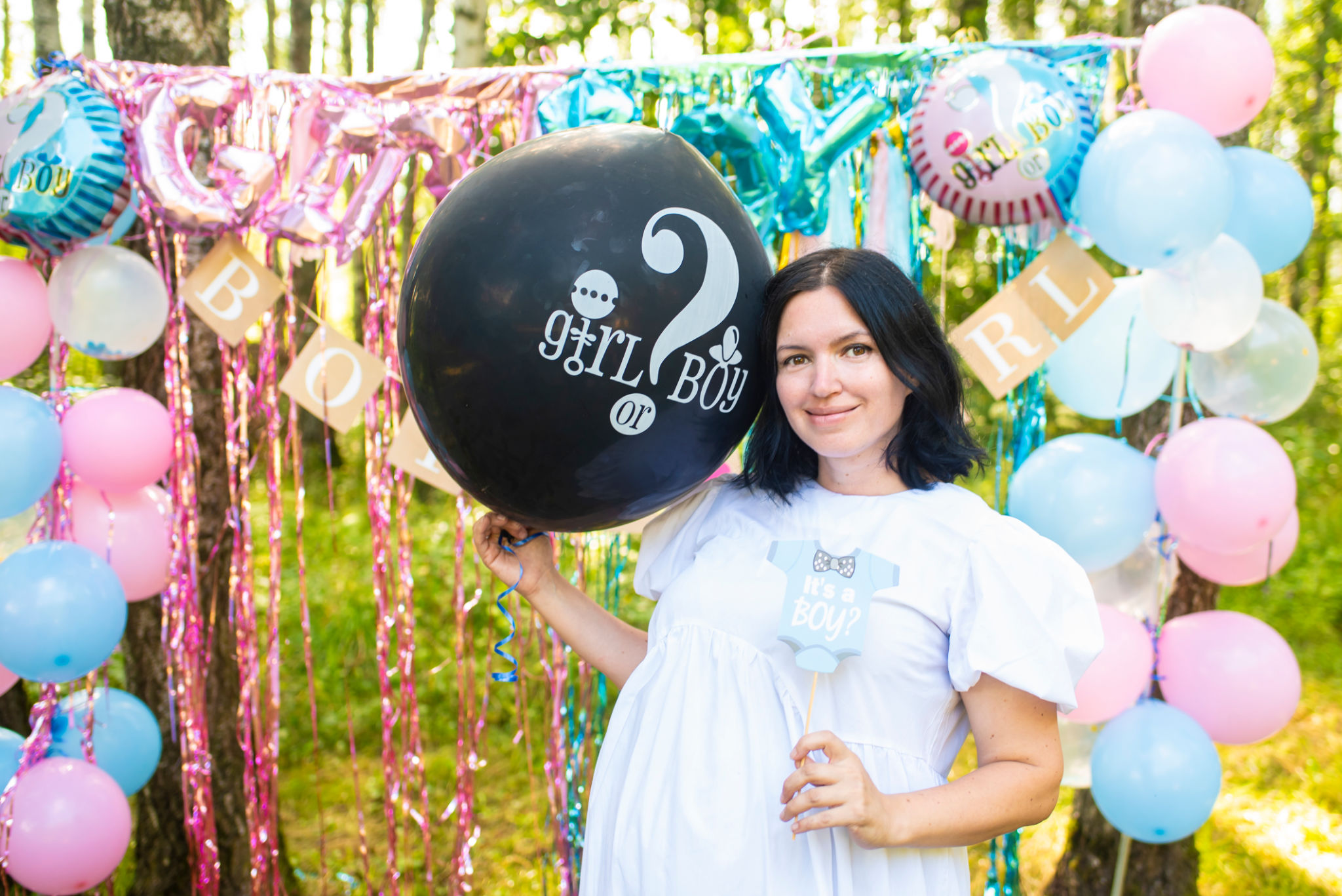 Pregnant 41 year old woman at Gender Reveal Party, holding black balloon with Pregnant 41 year old woman at Gender Reveal Party, holding black balloon with