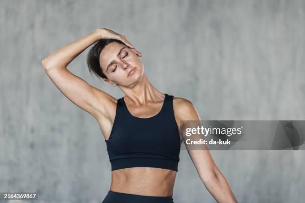 junge frau, die nackendehnungsübungen macht. dehnung und entspannung zur verbesserung von kraft und tonus. hintergrund für einen gesunden lebensstil und wohlbefinden - hals stock-fotos und bilder