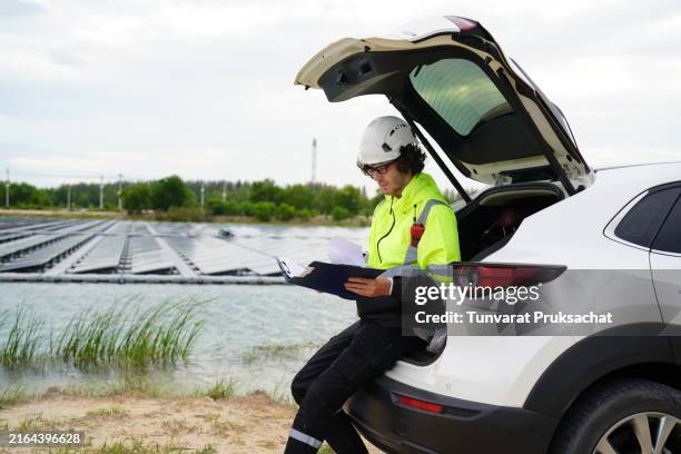 caucasian electrical engineer work on the site . - zonnecellen stockfoto's en -beelden