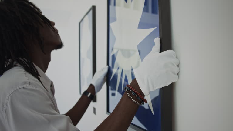 https://media.gettyimages.com/id/2164409352/video/black-gallery-worker-putting-picture-on-wall-in-exhibition-hall.jpg?b=1&s=640x640&k=20&c=5jSaZmECv3pJjxpWnoCsd1_OkC5Uecr7YhEMBHK9Va0=