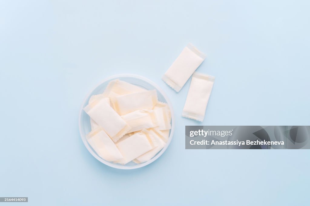 Open jar with snus pouches on blue background