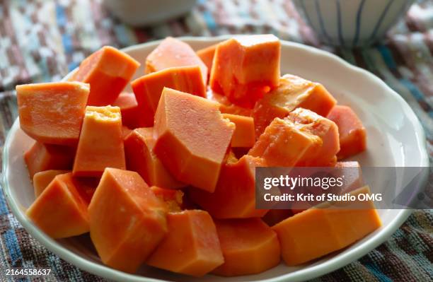 chopped ripe papaya on the white plate - papaye photos et images de collection