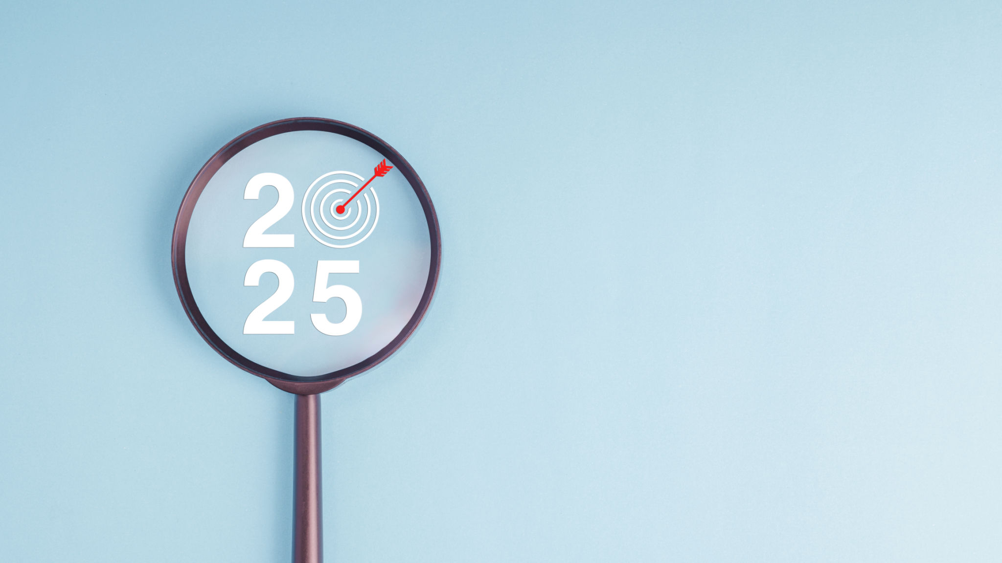 A magnifying glass is used to focus on number 2025 with dartboard and red arrow in concept of 2025 new year business strategy goal and target. A magnifying glass is used to focus on number 2025 with dartboard and red arrow in concept of 2025 new year business strategy goal and target.