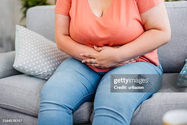 young woman having stomachache at home - flat abs woman stock pictures, royalty-free photos & images