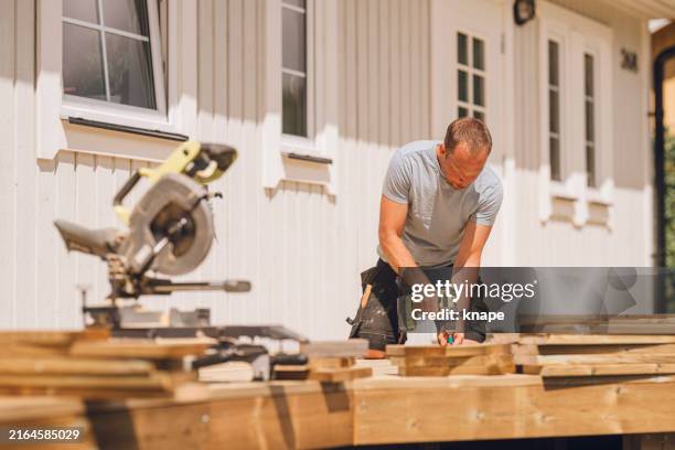 homme construisant une plate-forme en bois de patio à l’extérieur dans son jardin - menuiserie photos et images de collection
