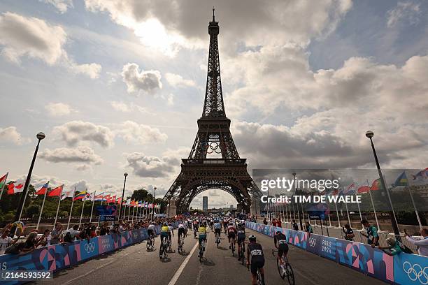 The pack of riders cycles at the foot of the Eiffel Tower at the start of the men's cycling road race during the Paris 2024 Olympic Games in Paris,...