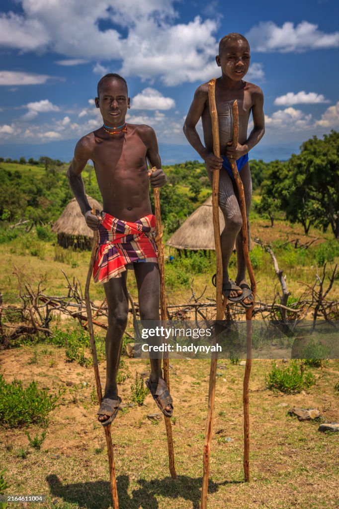 高床式の上を歩く若い男の子、エチオピア、アフリカ