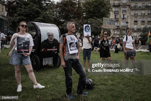 Protestors hold signs as they attend a demonstration in support for NGO Sea Shepherd Conservation Society Canadian founder Paul Watson in Paris on...