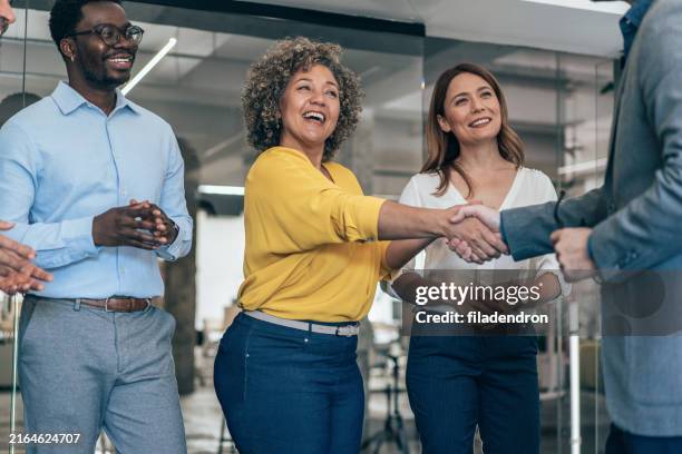business people shaking hands in the office - meet and greet stockfoto's en -beelden