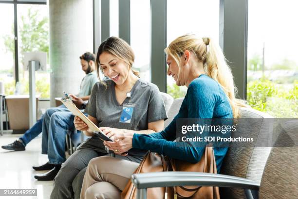 woman and female nurse happy about test results - outpatient care stock pictures, royalty-free photos & images