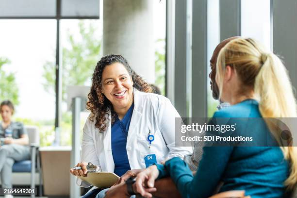allegra dottoressa ascolta la moglie del paziente - assistenza ambulatoriale foto e immagini stock