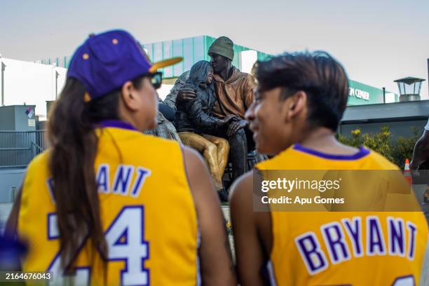 Pebbles Chavez and her grandson Cyris Govea observes a new permanent statue of Kobe Bryant and his daughter Gianna Bryant outside Crytpo.com Arena on...