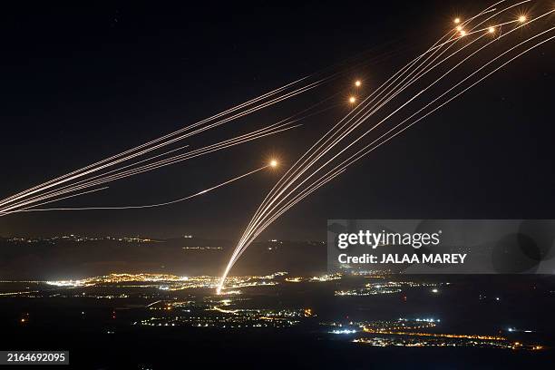 Rockets fired from southern Lebanon are intercepted by Israel's Iron Dome air defence system over the Upper Galilee region in northern Israel, on...