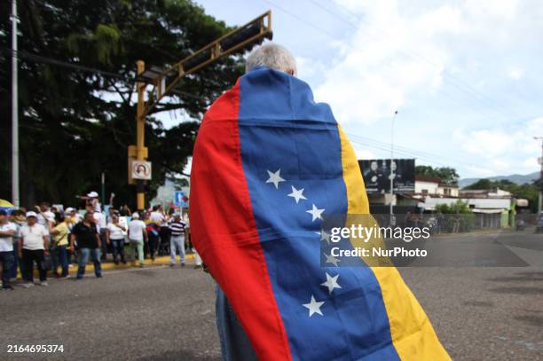 Person dressed with the Venezuelan flag is protesting during an opposition rally in San Cristobal, Venezuela, on August 3, 2024. Due to the crisis in...
